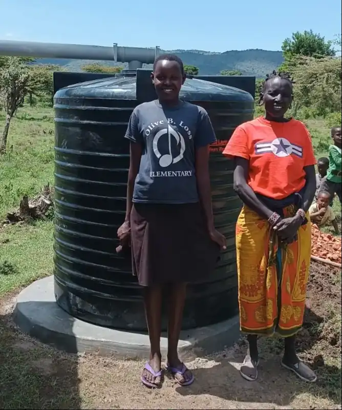 A Kenyan family beside their rainwater harvesting tank