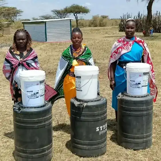 Kenyan women with rainwater tanks at their homes
